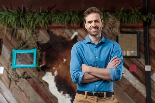 Gelukkig casual man houdt zijn handen gekruist op zijn borst — Stockfoto