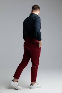 Merak eden moda adamı iki elini de cebinde tutuyor.