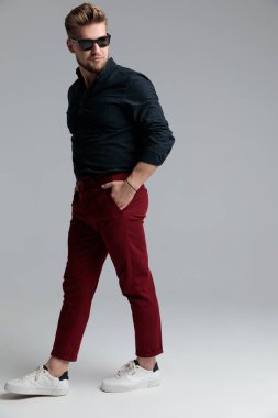 Ciddi görünüşlü moda adamı ellerini cebinde tutuyor.