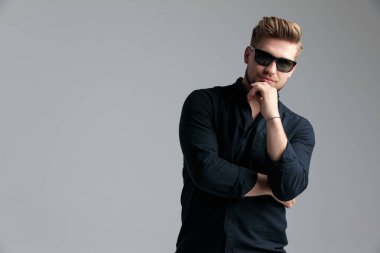 Moda adamı elini çenesinde tutuyor.