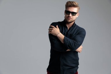Kollarını göğsünde kavuşturan sert moda adamı. 