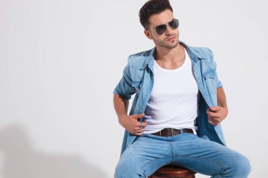 Motive olmuş sıradan bir adam ceketini ayarlıyor ve başka tarafa bakıyor.