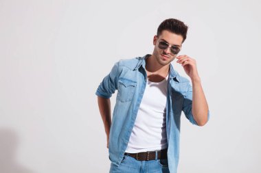 Yakışıklı, sıradan bir adam güneş gözlüğünü çıkarmak üzere. 