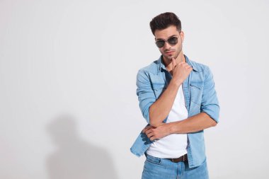 İlgilenen moda adamı elini çenesinde tutuyor.