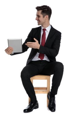 Çekici iş adamı tabletini yan tarafa sunuyor.