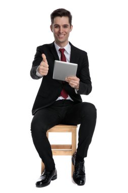 Neşeli iş adamı tabletini tutuyor ve onayı veriyor.