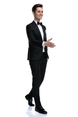 Gülümseyen genç, zarif bir model el sıkışıyor ve yürüyor.