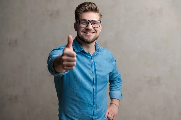 Modern avslappnad man ger tummen upp och ler — Stockfoto