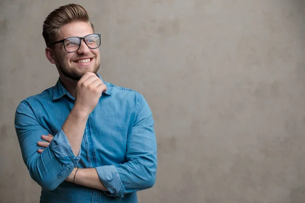 Förhoppningsfull avslappnad man tittar bort med handen på hakan — Stockfoto