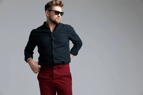 Detemined moda uomo adjusitng i pantaloni e guardando — Foto Stock