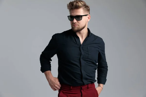 Convinced fashion man adjusitng his pants and looking away — Stock Photo, Image