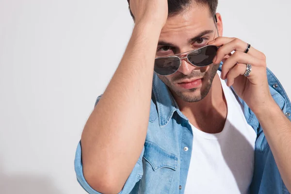 Nahaufnahme eines entschlossenen Modemanns, der seine Sonnenbrille justiert — Stockfoto