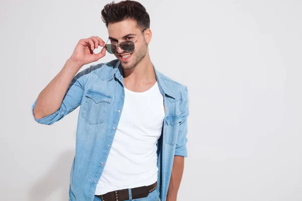 Cheerful casual man taking off his sunglasses and laughing — Stock Photo, Image