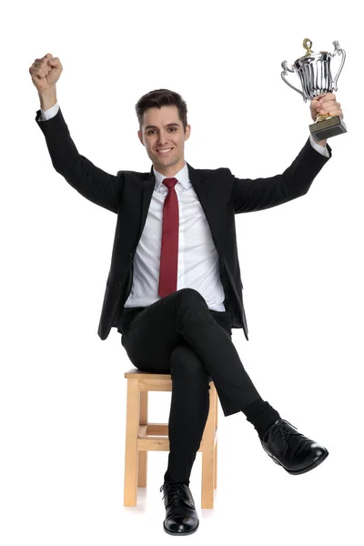 Positive businessman holding his trophy above his head — Stock Photo, Image