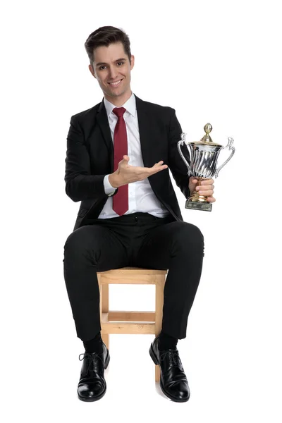 Fröhlicher Jungunternehmer präsentiert seine Trophäe — Stockfoto