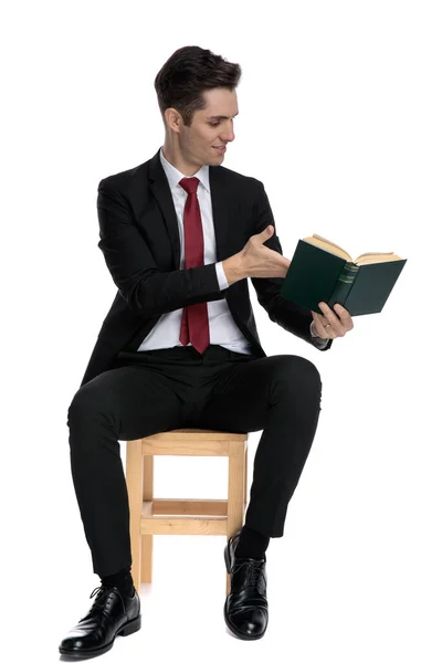 Feliz joven empresario presentando un libro a un lado — Foto de Stock