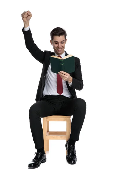 Eleganter Geschäftsmann feiert und hält ein Buch in der Hand — Stockfoto