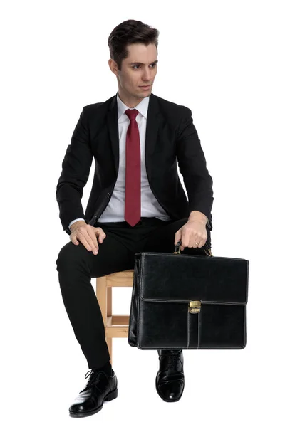 Empresario motivado sosteniendo su maletín y mirando hacia otro lado — Foto de Stock
