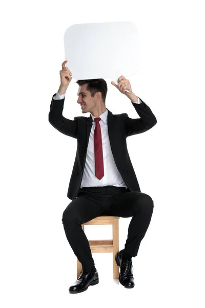 Hombre de negocios alegre sosteniendo una burbuja del discurso sobre su cabeza — Foto de Stock