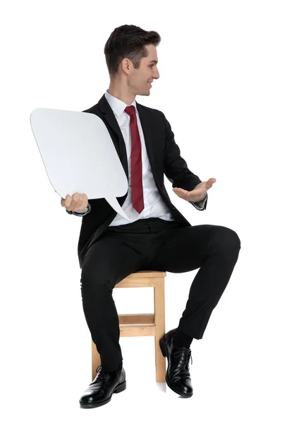 Handsome young businessman presenting a speech bubble to the sid — Stock Photo, Image