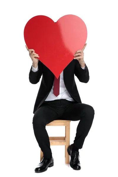 Misterioso hombre de negocios cubriendo su cara con una forma de corazón — Foto de Stock