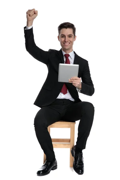 Veselý podnikatel slaví a drží svůj tablet — Stock fotografie
