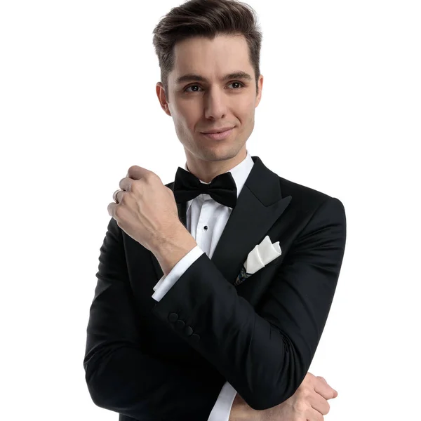 Smiling young groom in tuxedo smiling and looking to side — Stock Photo, Image
