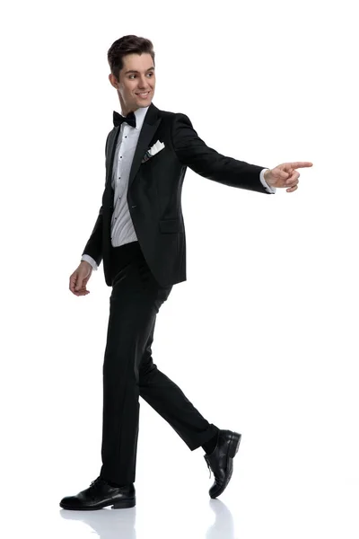 Vista lateral do elegante noivo andando e apontando o dedo — Fotografia de Stock