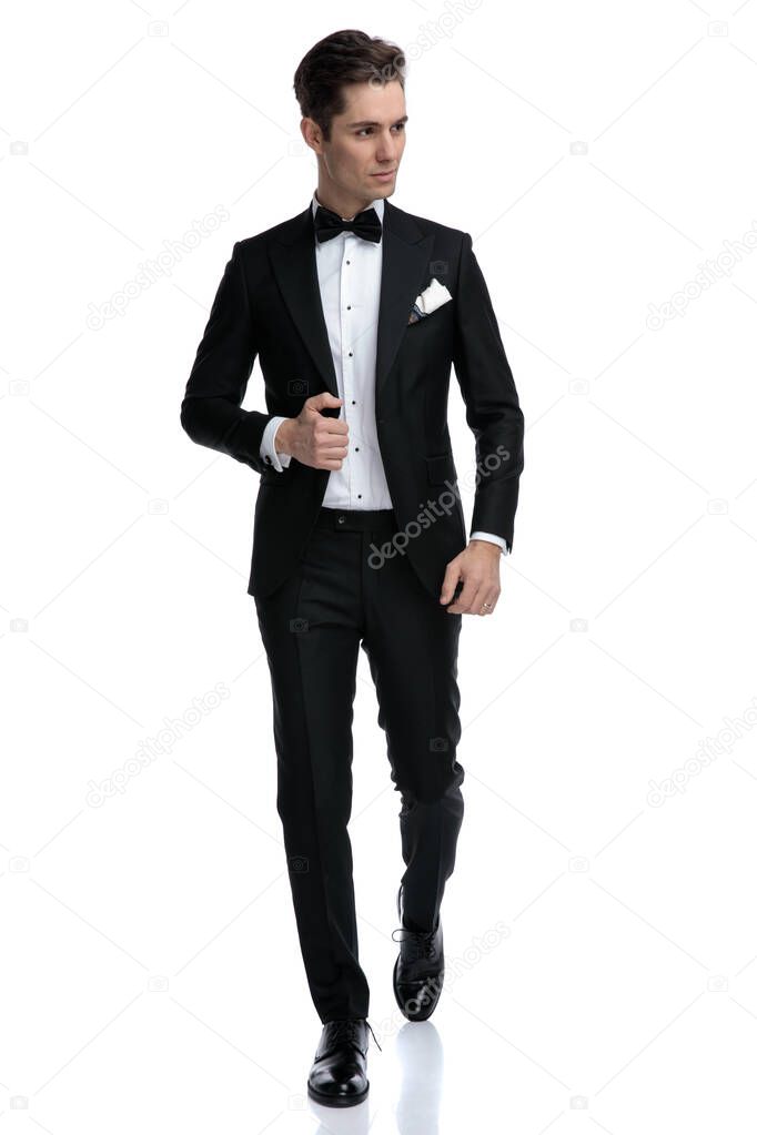 elegant young man walking and looking to side