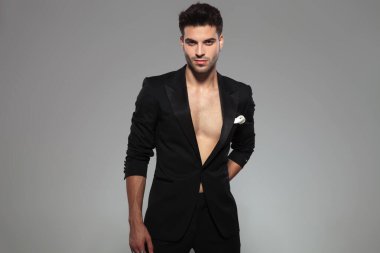 Moda adamı ayakta ve arkasında bir hediye saklıyor.