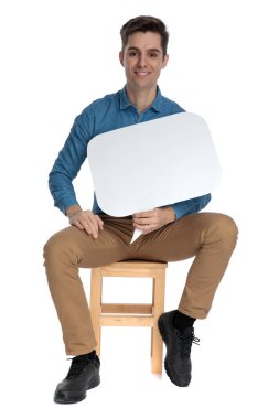 Genç ve zarif bir adam konuşma balonu tutuyor ve gülümsüyor.