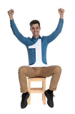 Havada yumrukları tutan ve zaferi kutlayan mutlu genç adam.