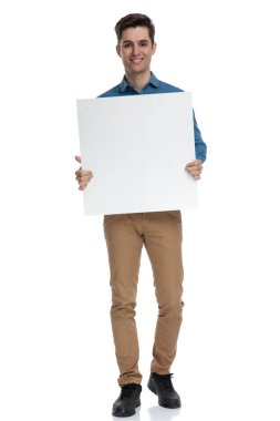 Mutlu genç adam gülümsüyor ve elinde boş tahtayla