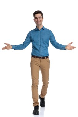 Mutlu genç adam gülümsüyor ve kollarını açıyor. 