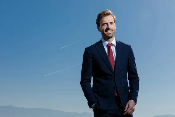 Hoffnungsvoller Geschäftsmann, der mit der Hand in der Tasche wegschaut — Stockfoto