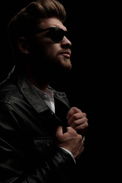 Man wearing sunglasses standing and pulling jacket while looking — Stock Photo, Image