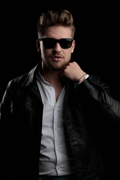 Casual man wearing sunglasses standing and fixing his collar — Stockfoto