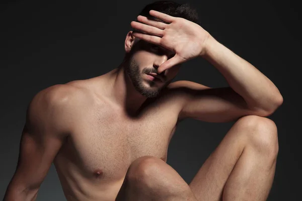 Dramatic naked cool guy avoiding light — Stock Photo, Image