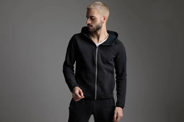 Casual man wearing tracksuit standing and looking aside serious — Stock Photo, Image