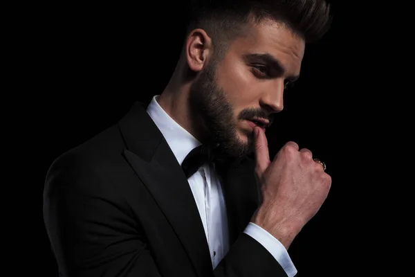 Businessman wearing black tuxedo seductively touching lips — Stock Photo, Image
