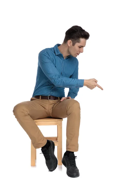 Homem casual inteligente na camisa azul apontando dedo para baixo lado — Fotografia de Stock