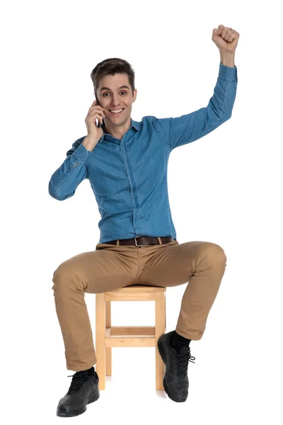 Animado jovem falando ao telefone e celebrando a vitória — Fotografia de Stock