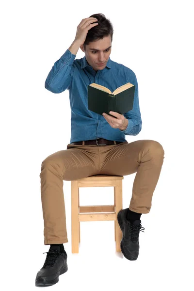 Hombre casual inteligente cogido de la mano a la cabeza y la lectura —  Fotos de Stock