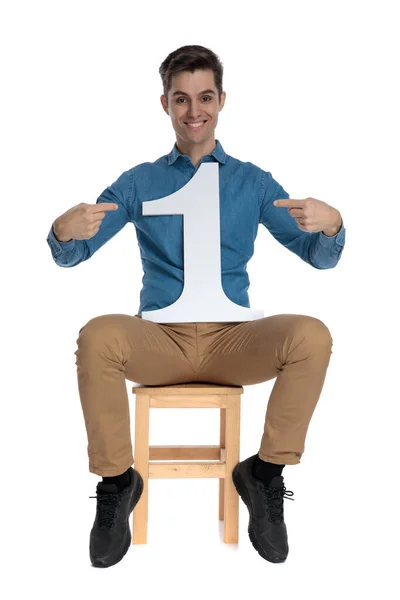 Happy young man pointing finger to number one sign — Stockfoto