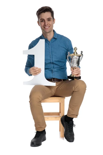 Gelukkige jongeman met trofee en nummer een teken — Stockfoto