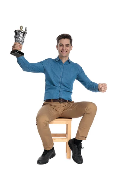 Boldog fiatalember kezében trófea és ünneplő győzelem — Stock Fotó