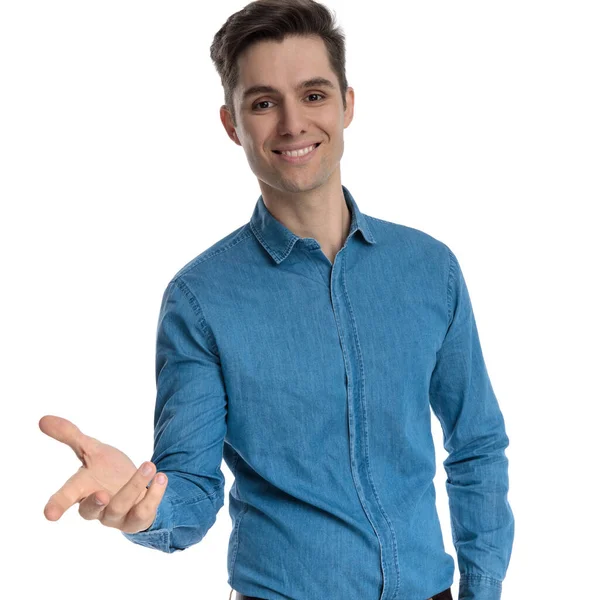 Boldog fiatalember kék ingben mosolyog és fogja a kezét — Stock Fotó