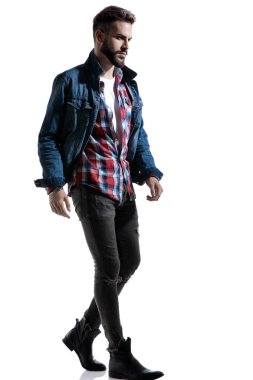 Ekose gömlekli seksi manken yürüyor ve yan tarafa bakıyor.