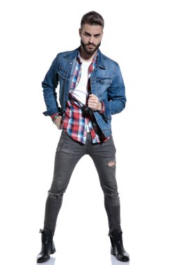 Kareli gömlekli dramatik havalı adam moda pozunda duruyor.