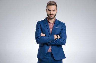 Mavi elbiseli mutlu genç manken kollarını kavuşturuyor.